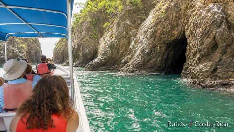 Lancha turística navegando junto a acantilados rocosos en la costa del Pacífico Sur de Costa Rica