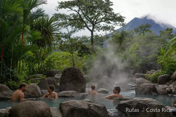 Aguas termales naturales entre vegetación tropical cerca de La Fortuna con vapor visible