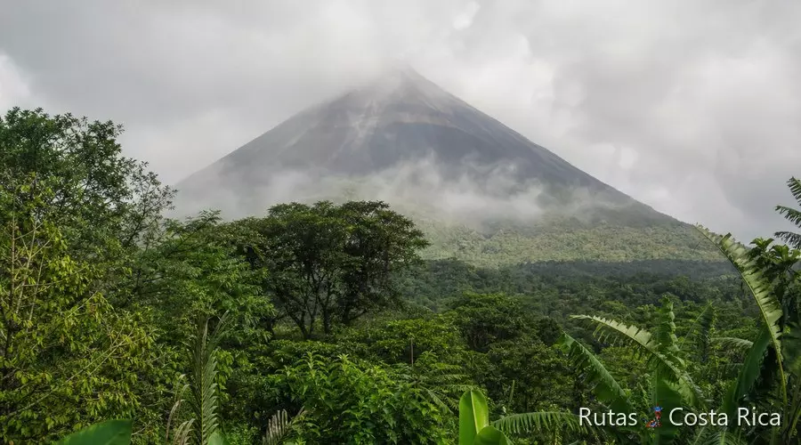Volcán Arenal entre nubes vistas desde la selva de La Fortuna, Costa Rica